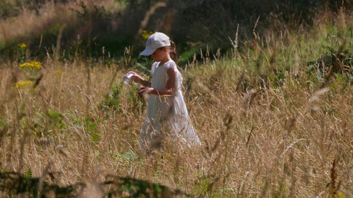 Girl in white dress in long grass